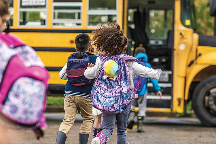 children getting on school bus
